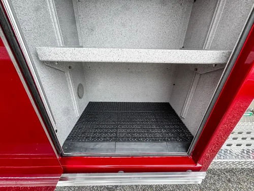 Deep side compartment interior close-up with wiring and textured liner.